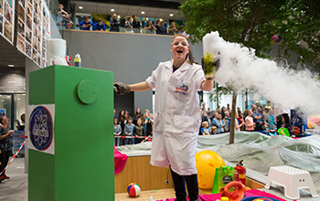 Mad Scientist holding a beaker with dry ice in side and smoke existing the top
